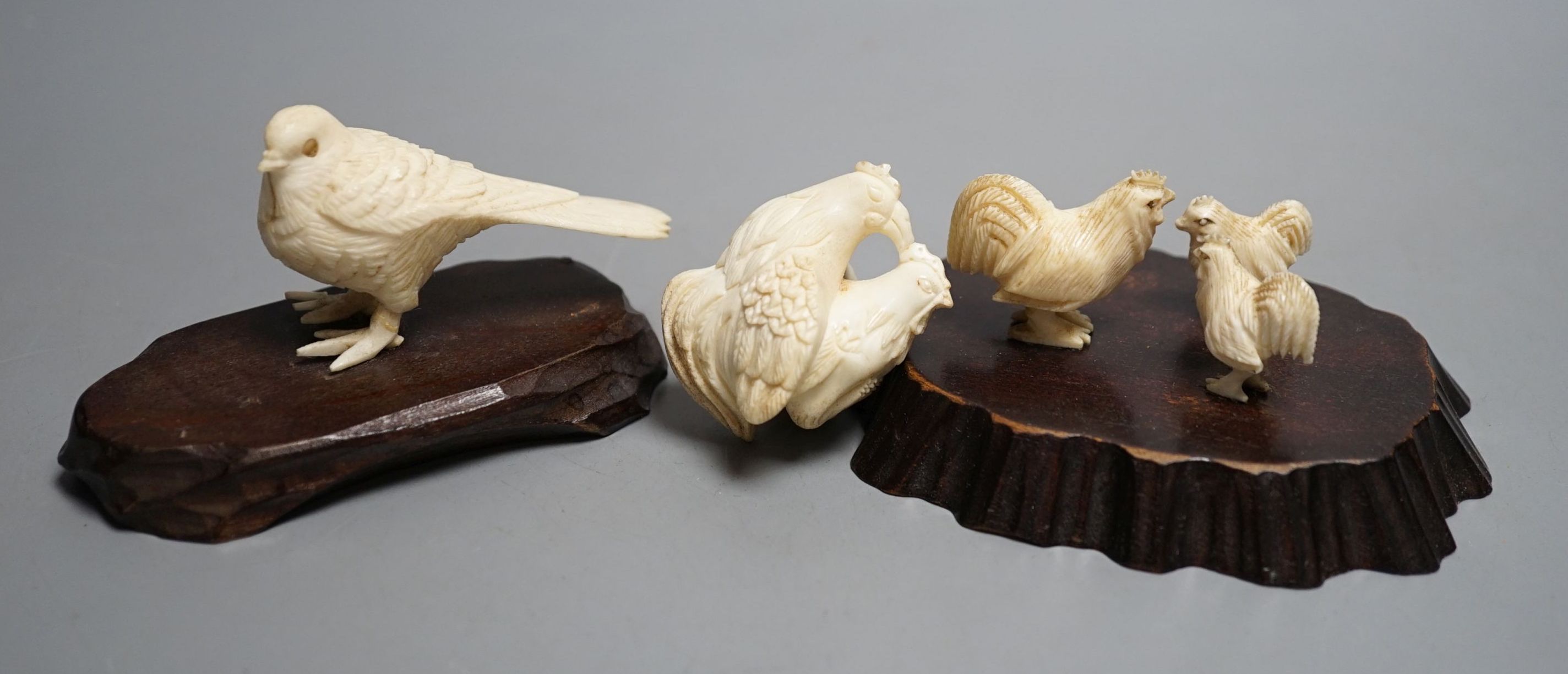 A Japanese Meiji period ivory bird with mother of pearl eyes, a Japanese group of three chickens and Japanese copulating chickens